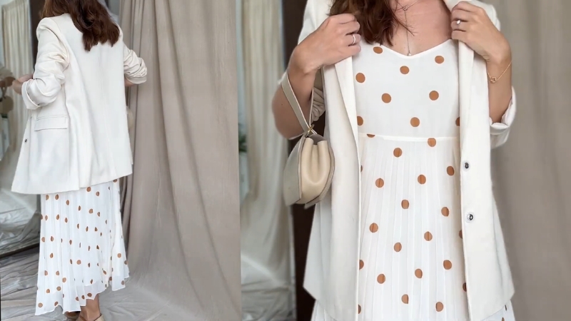 Žena nosi belu haljinu sa braon tačkicama uz svetli sako, u elegantnoj jesenjoj kombinaciji
